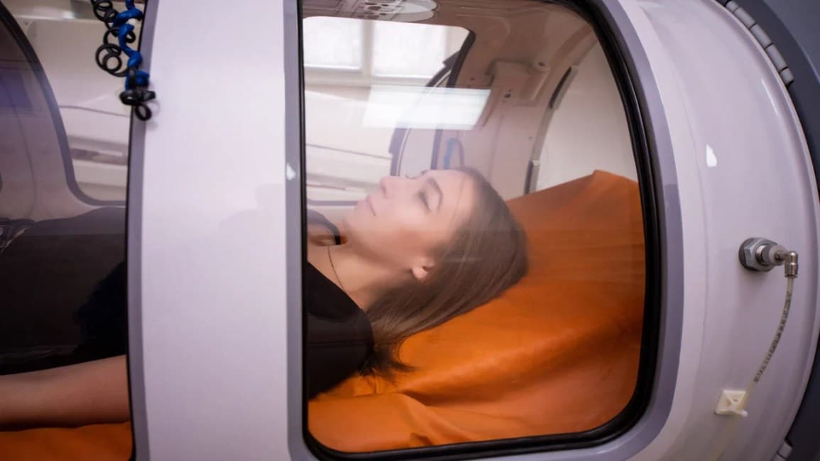 A lady sleeping inside a hyperbaric chamber